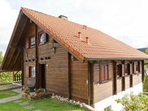 a small wooden house with a red roof at Chalet in Hinterrod Thuringia with sauna in Eisfeld
