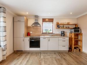 a kitchen with white cabinets and a sink at Vacation home with garden in beautiful Sauerland in Kirchhundem