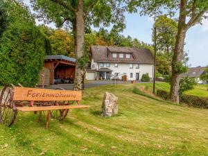 a bench sitting in the grass in front of a house at Vacation home with garden in beautiful Sauerland in Kirchhundem