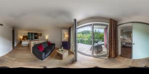 ein Wohnzimmer mit einem Sofa und einem Balkon in der Unterkunft Hotel Spechtshaardt in Rothenbuch
