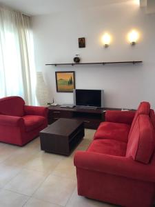 Exclusive Big Villa في بايالا: غرفة معيشة مع كنبتين حمراء وتلفزيون