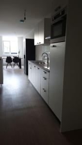 
a kitchen with a stove, microwave and refrigerator at Apartamenty Eindhoven in Eindhoven
