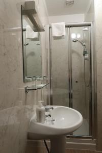 bagno bianco con lavandino e doccia di Corunna Bed & Breakfast and Garden Cottage a Inverness