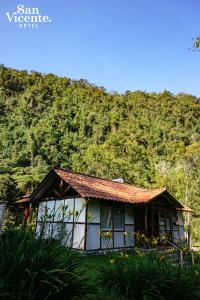 a house with a wooden roof and trees at Hotel Termales San Vicente in Santa Rosa de Cabal