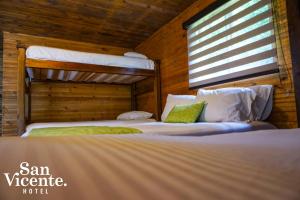a bedroom with two bunk beds and a window at Hotel Termales San Vicente in Santa Rosa de Cabal