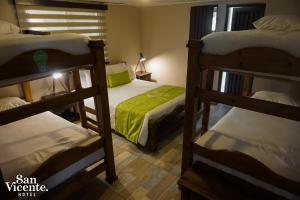 聖羅莎德卡瓦爾的住宿－Hotel Termales San Vicente，一间卧室配有三张双层床。