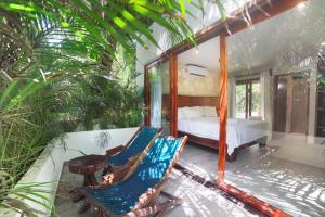 a bedroom with a bed and two chairs at Playa Canek Beachfront Eco Hotel in Tulum