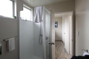 a bathroom with a shower and a glass door at Aden Motel in Te Anau