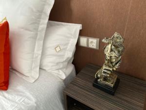 un trofeo sentado en una mesa junto a una cama en Apartamentos "El Escondite de Triana", en Sevilla