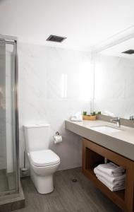 a bathroom with a toilet and a sink and a mirror at Madison Capital Executive Apartments in Canberra