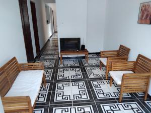 een woonkamer met stoelen en een bank en een tv bij Acupe de Brotas in Salvador