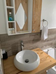 ein Badezimmer mit einem weißen Waschbecken und einem Spiegel in der Unterkunft El Doral in San Felipe de Puerto Plata