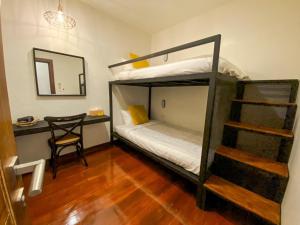 a room with a bunk bed and a desk with a mirror at บ้านในกาด-ที่พักน่าน โรงแรมน่าน เที่ยวน่าน in Nan