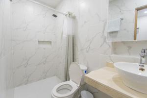 辛塞莱霍Stanza Hotel Sincelejo的带马桶和水槽的白色浴室