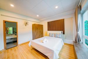 a bedroom with a white bed and a large window at Kien Vang Bungalow in Phu Quoc