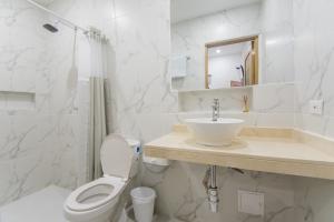 ein weißes Bad mit einem WC und einem Waschbecken in der Unterkunft Stanza Hotel Sincelejo in Sincelejo