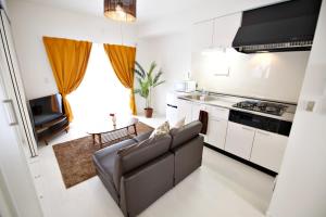 a living room with a couch and a kitchen at Vent du Vent302 in Minatogawa