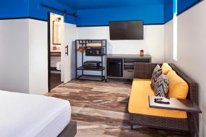 Cette chambre comprend un lit, un canapé et une télévision. dans l'établissement Pacific View Inn, à San Diego