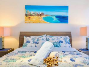 a bedroom with a bed with a view of a beach at By The Beach Frankston in Frankston