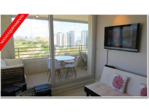 sala de estar con vistas a un balcón en Apartamento Concon - Costas del Mar, en Viña del Mar