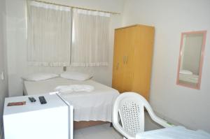 a small bedroom with a bed and a cabinet at Nacional Hotel in Itacarambi