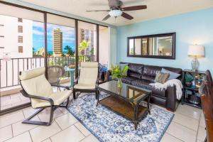 een woonkamer met een bank en stoelen bij Beach Lover's Haven, Cozy Condo with Ocean Views and Free Parking in Honolulu