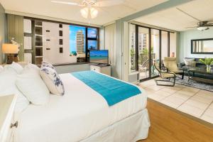 een slaapkamer met een groot bed en een woonkamer bij Beach Lover's Haven, Cozy Condo with Ocean Views and Free Parking in Honolulu