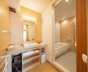 a bathroom with a sink and a bath tub at Kurashiki Ivy Square in Kurashiki