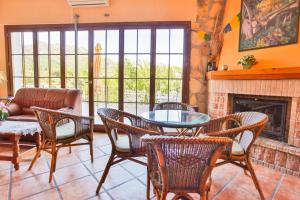 sala de estar con mesa, sillas y chimenea en Hotel Rural Serrella, en Castell de Castells