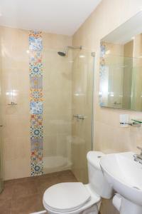 a bathroom with a toilet and a shower and a sink at Casa Caribe Colonial in Barranquilla