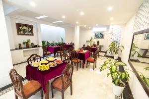 a restaurant with purple tables and chairs and plants at SHALA BOUTIQUE HOIAN in An Bang