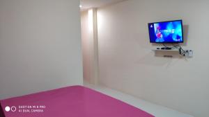 a room with a tv and a purple mattress at สังขละการ์เด้นโฮม in Sangkhla Buri