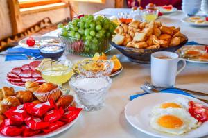 a table topped with plates of breakfast foods and drinks at Feel Nomad Yurt Camp in Ak-Say