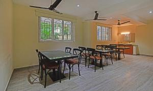 a group of tables and chairs in a room at Treebo Trend Samhaar Residency Thoraipakkam in Chennai