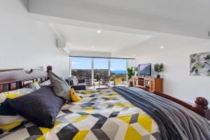 a bedroom with a large bed with a large window at Views Forever - Devonport in Devonport