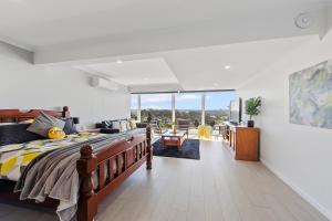 
a bedroom with a bed, table and a window at Views Forever - Devonport in Devonport
