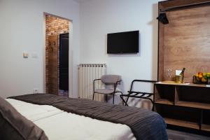 una camera d'albergo con letto, scrivania e TV di Bužinel rooms a Dobrovo