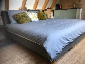 a bed with a blue comforter and two pillows at T’ Hogeland Ainrom in Eenrum