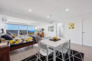 a kitchen with a table, chairs, and a large window at Views Forever - Devonport in Devonport