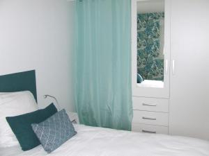 a bedroom with a bed and a dresser with a mirror at Gîte les Hortensias in Beauquesne