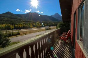 a bench on a balcony with a view of a mountain at Bighorn Inn & Suites in Canmore