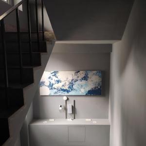 a bathroom with a sink and a painting on the wall at EasyLiving in Tainan