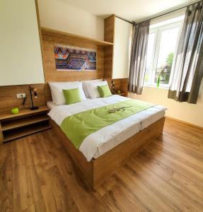 um quarto com uma cama grande e pisos em madeira em Life Hostel Slovenia em Radovljica