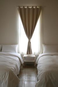 鵝鑾的住宿－窩在海邊民宿，带窗户的客房内的两张床
