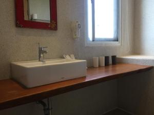 a white sink on a wooden counter in a bathroom at Seashore My Home in Eluan