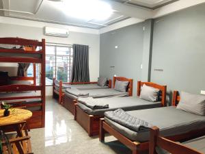 a room with four bunk beds and a table at Homestay Nhà Muội in Quy Nhon