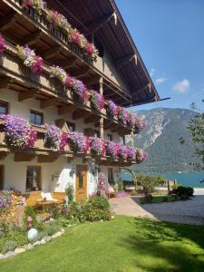 un edificio con flores a un lado. en Seepension Knappenhof, en Pertisau