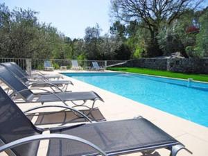 een zwembad met ligstoelen naast een zwembad bij Villa la Grette in Fayence