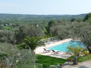 een zwembad in een tuin met bomen en een hek bij Villa la Grette in Fayence