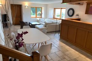a kitchen and living room with a white table and chairs at Domaine des Pierres D Auvergne in Flat